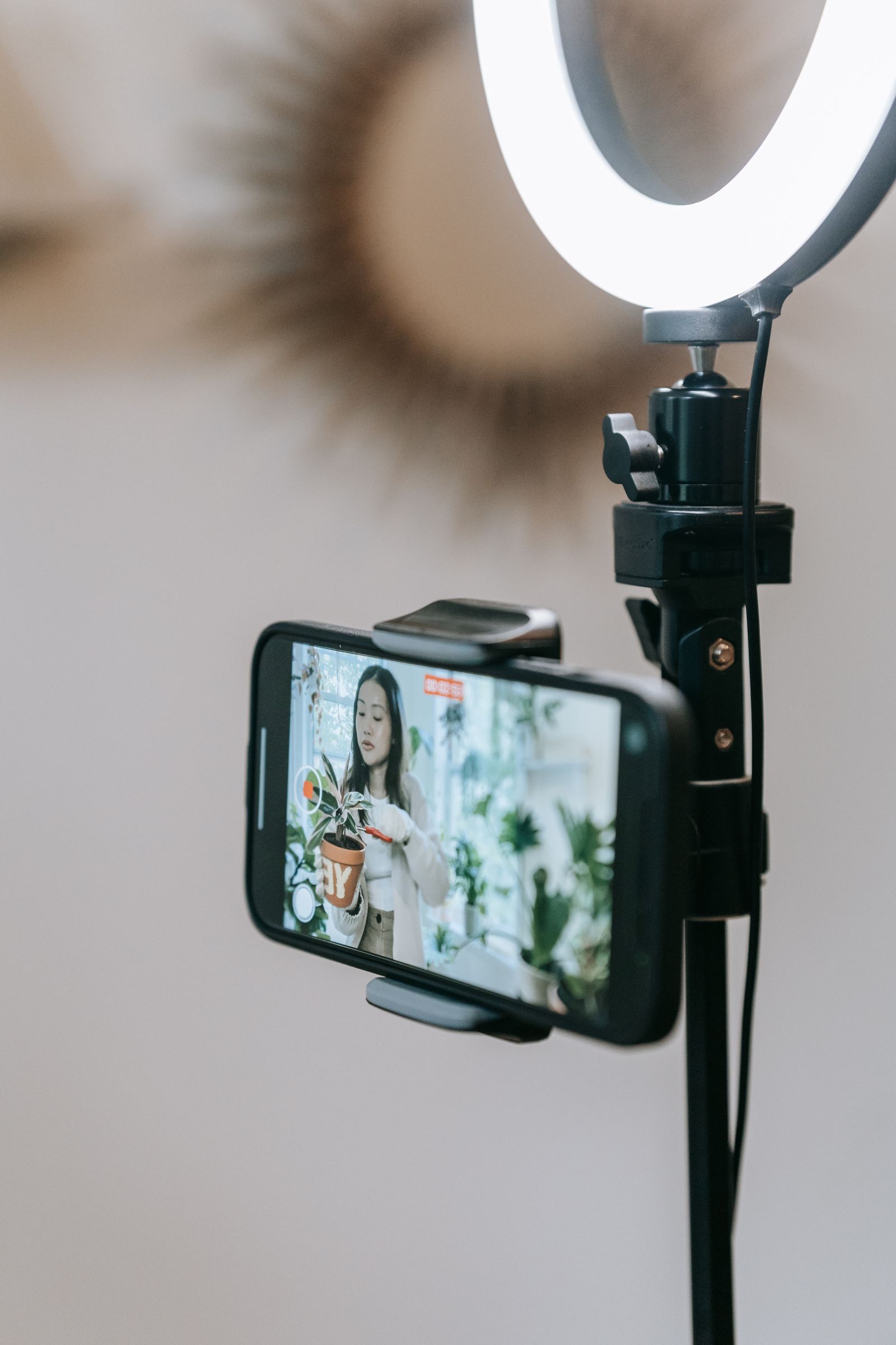 Content creator filming vertical video with a smartphone and ring light for a video first platform
